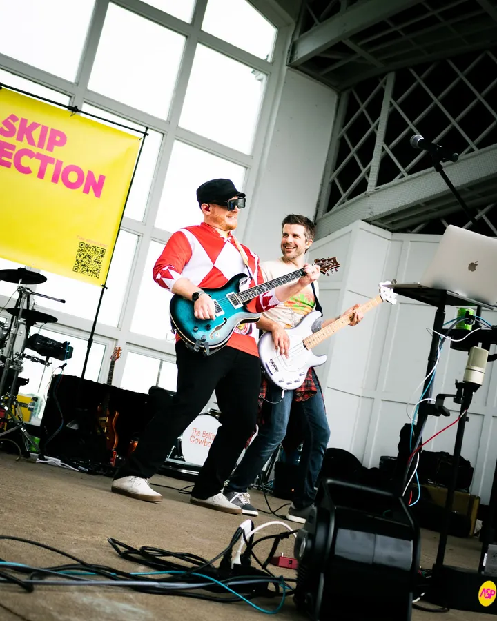 The band on stage under the yellow Anti-Skip Protection banner